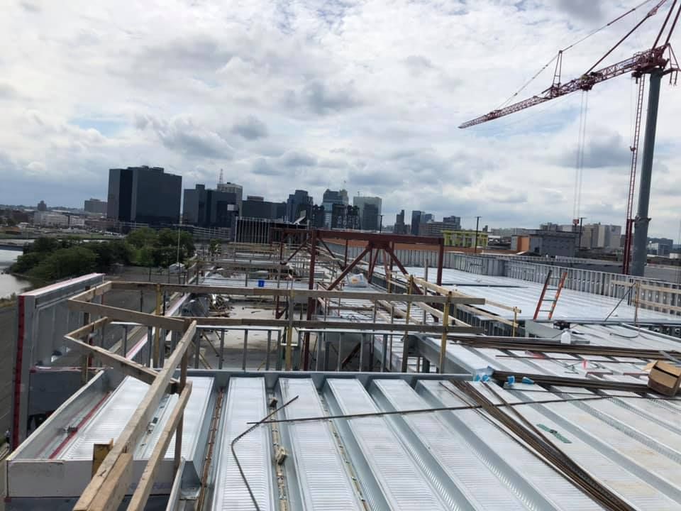 A construction site with a city in the background and a crane in the foreground.