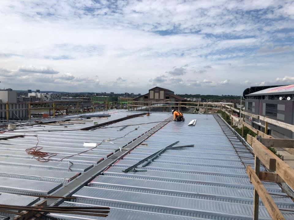 A group of construction workers are working on the roof of a building.