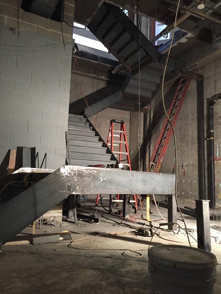 A building under construction with stairs and a ladder