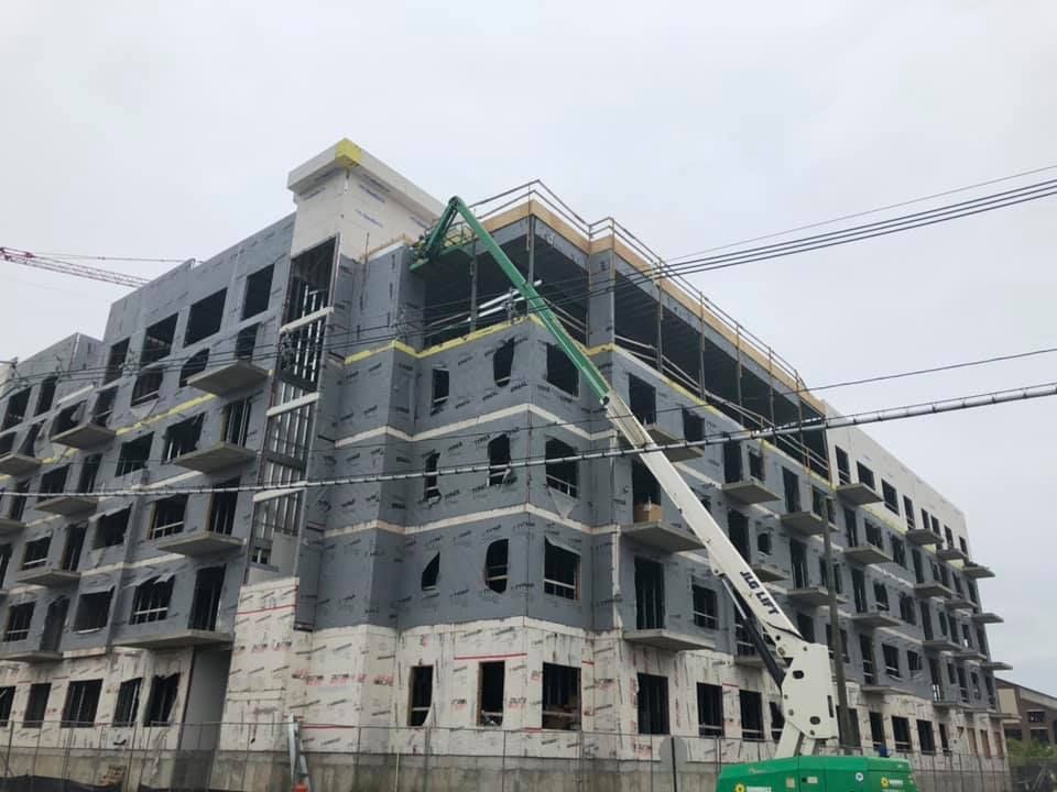 A large building under construction with a crane on top of it.
