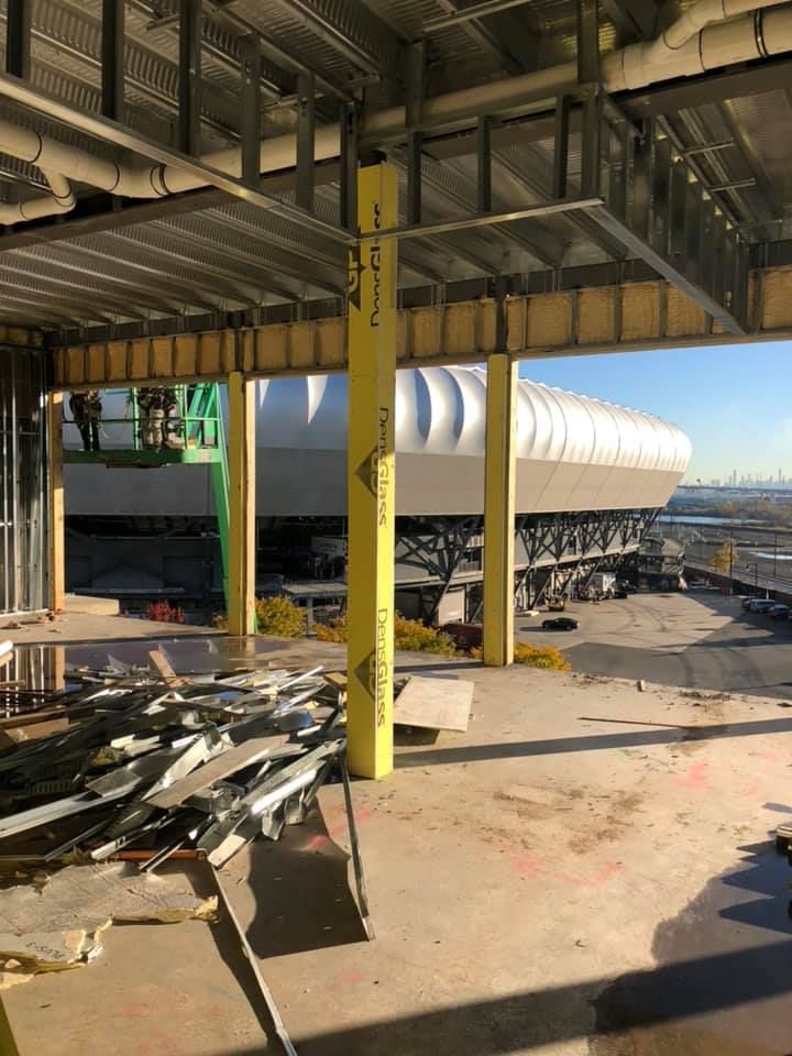 The inside of a building under construction with a large building in the background.