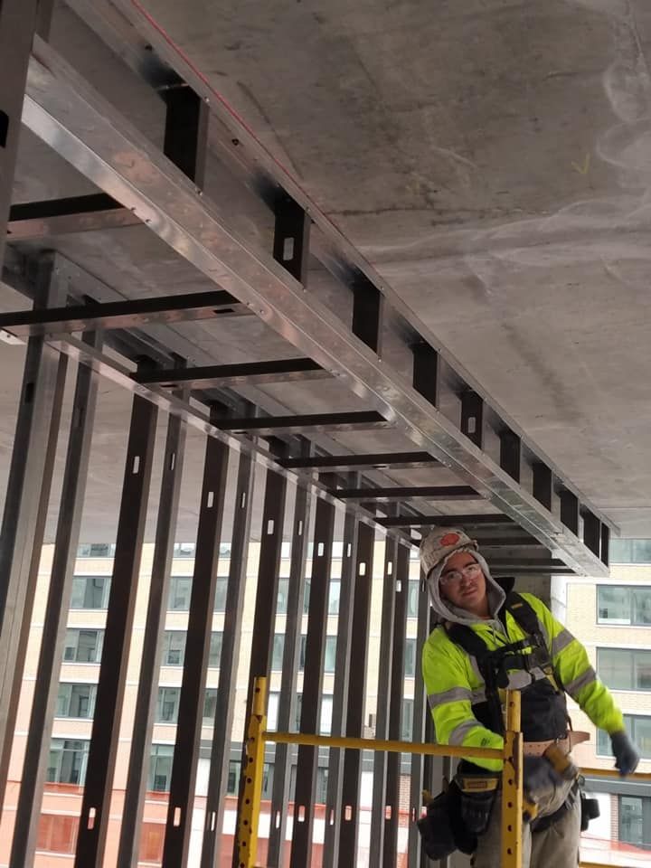 A man is standing on a scaffolding in a building under construction