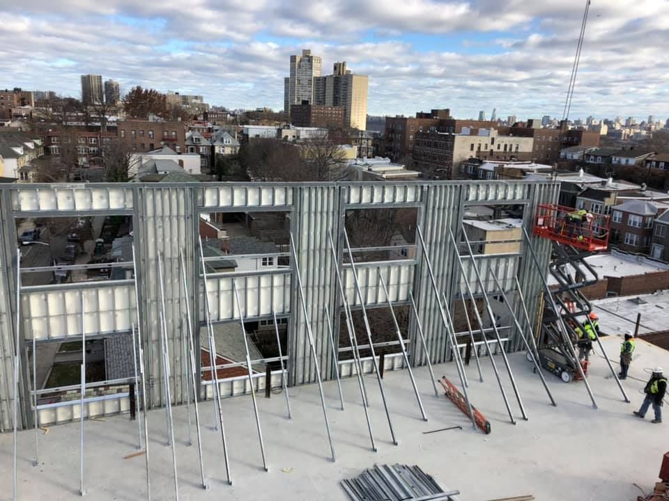 An aerial view of a building under construction with a city in the background.