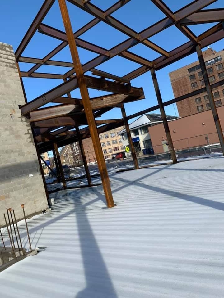 A building under construction with a roof that is covered in snow