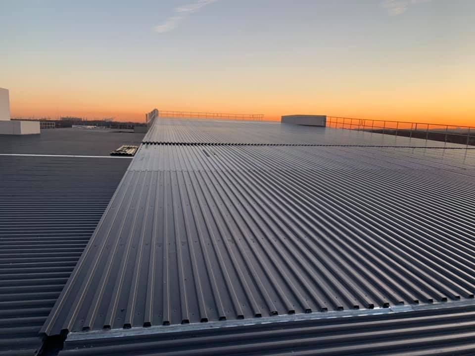 A close up of a roof with a sunset in the background.