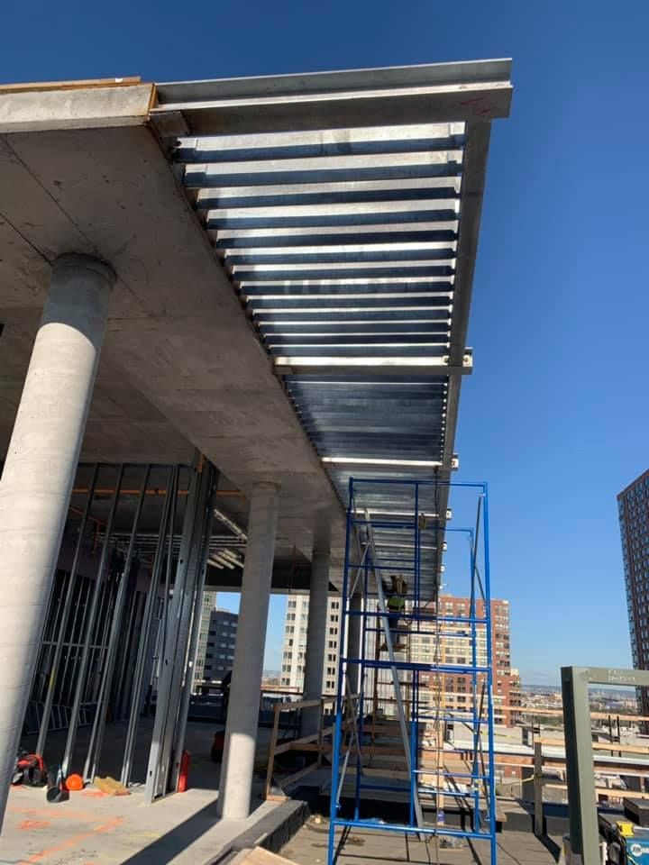 A building under construction with a blue scaffolding in front of it