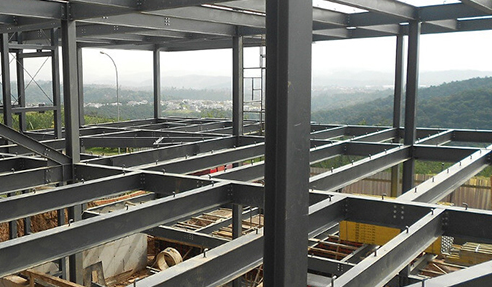 A large building under construction with a view of the mountains in the background.