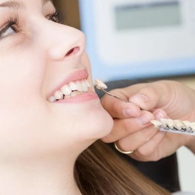 smiling woman getting her teeth checked for veneers