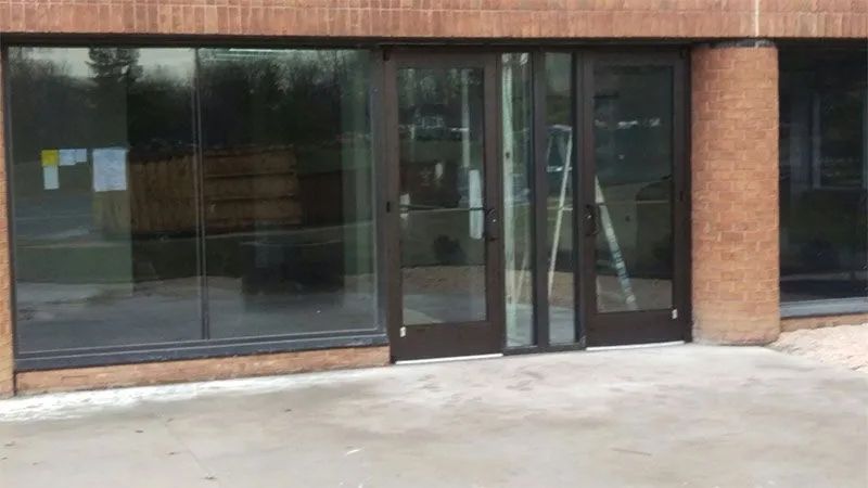 A brick building with a lot of glass doors and windows.