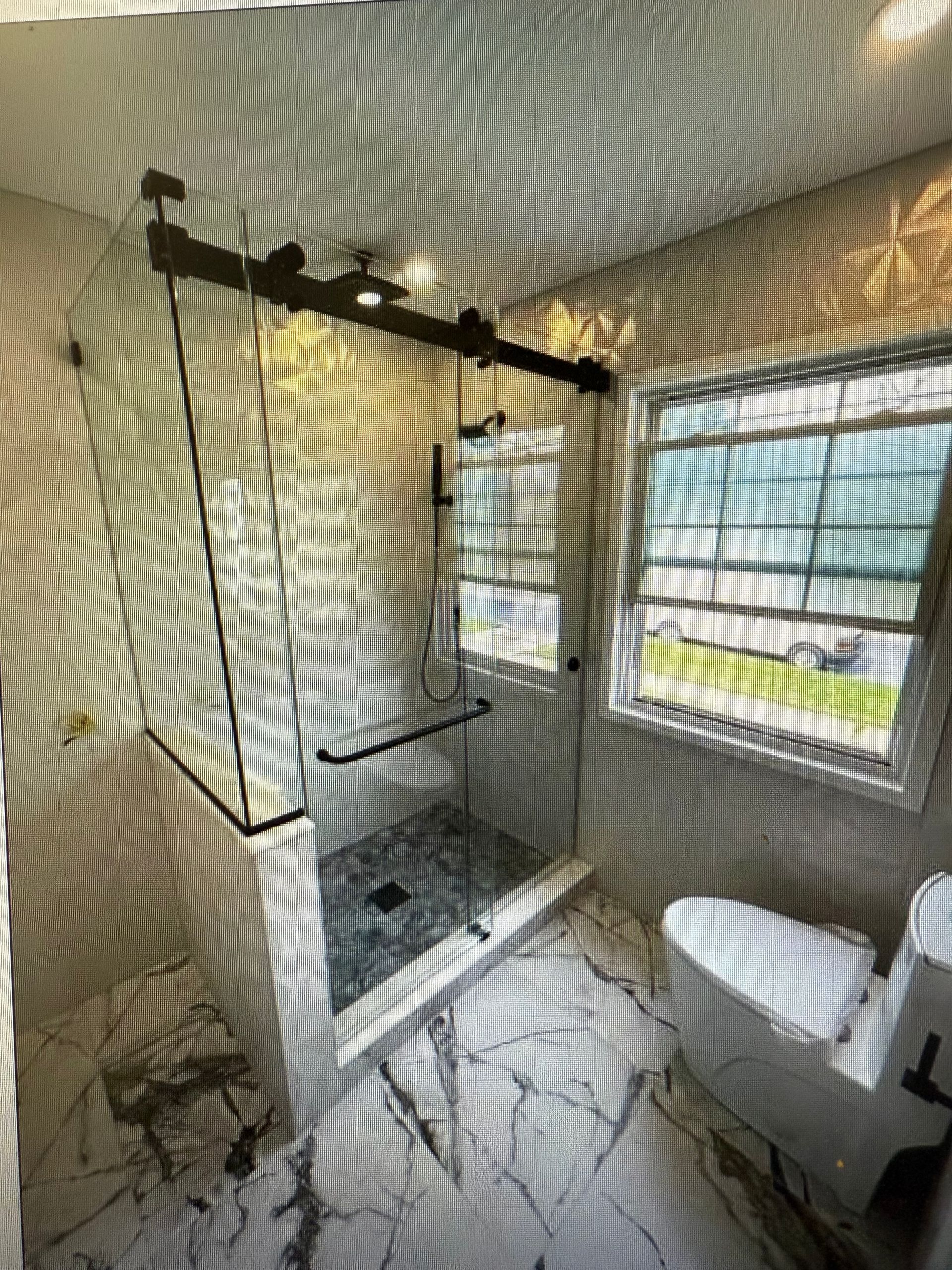 A bathroom with a sliding glass shower door and a toilet.