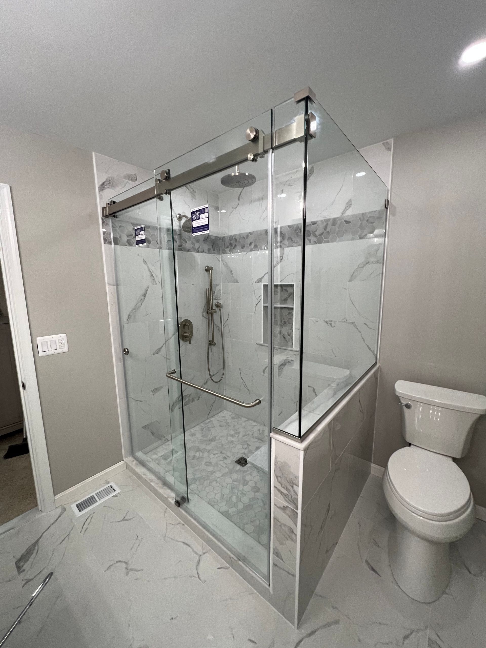 A bathroom with a sliding glass shower door and a toilet.