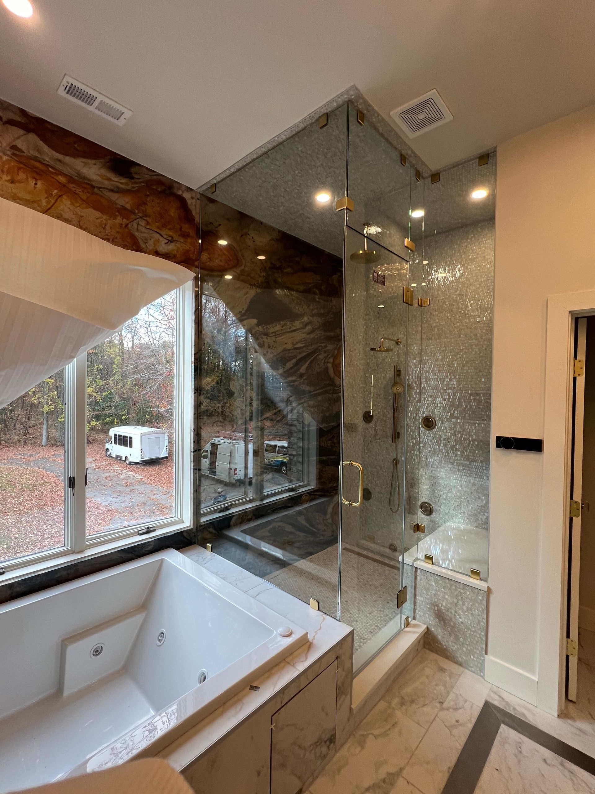 A bathroom with a jacuzzi tub and a walk in shower.