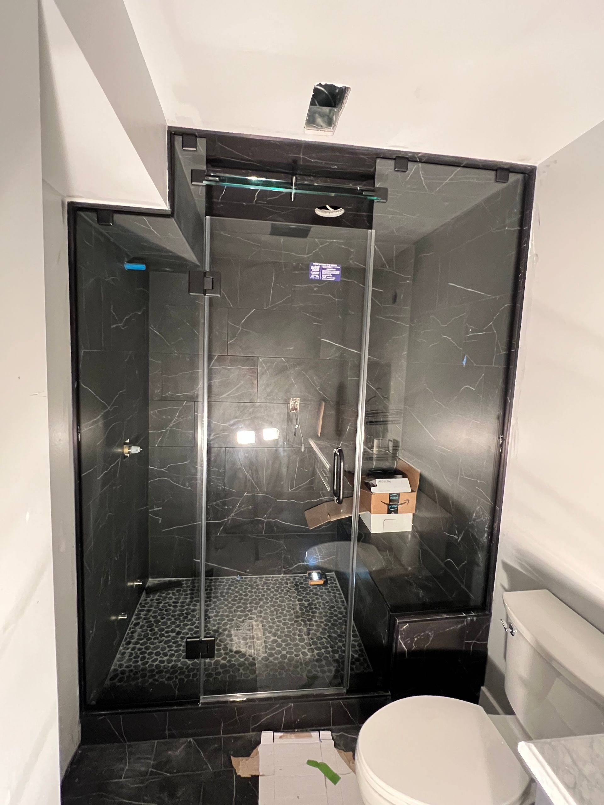 A bathroom with a toilet and a shower stall with a glass door.