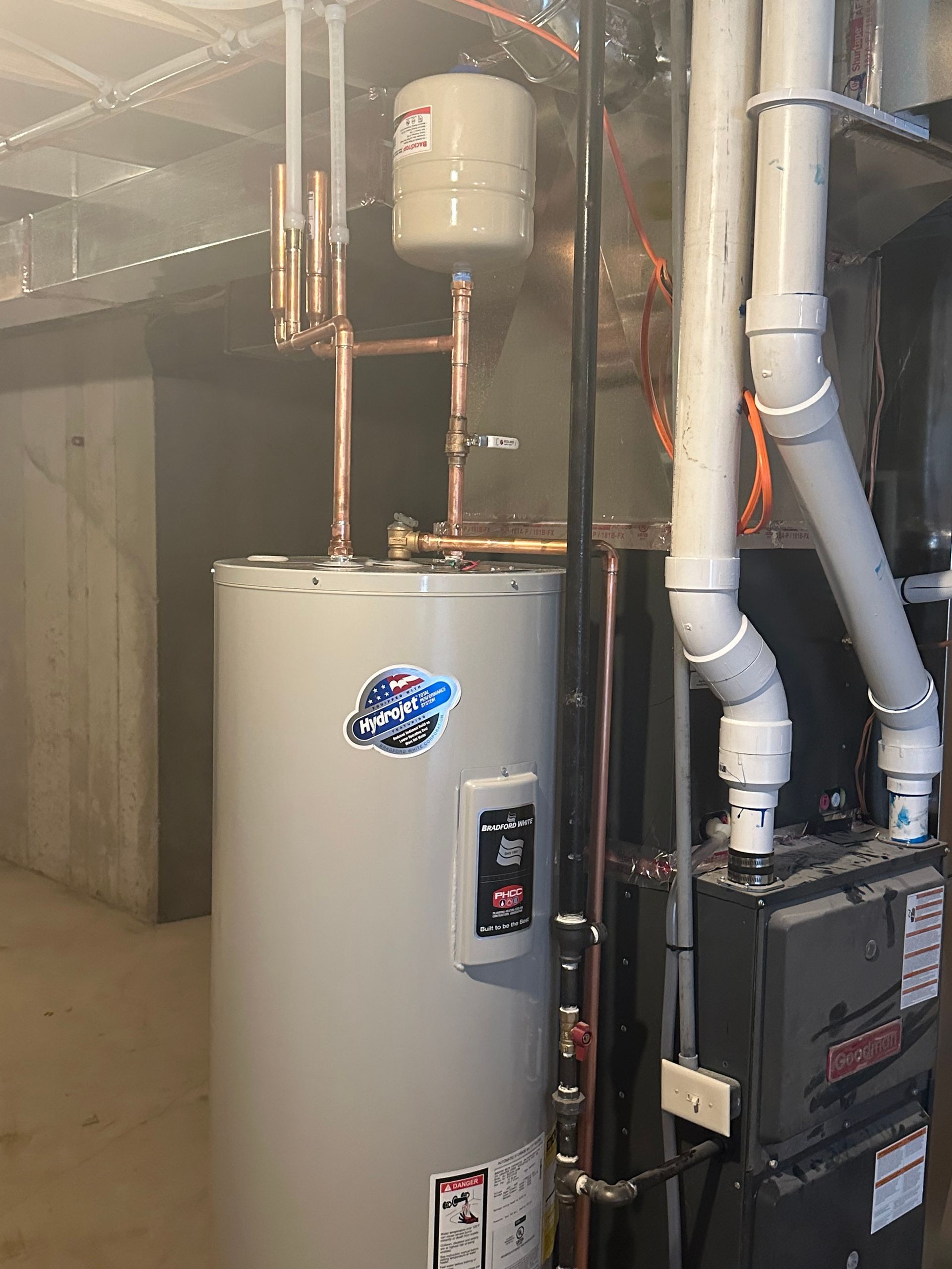 Water heater and furnace in a basement setting.