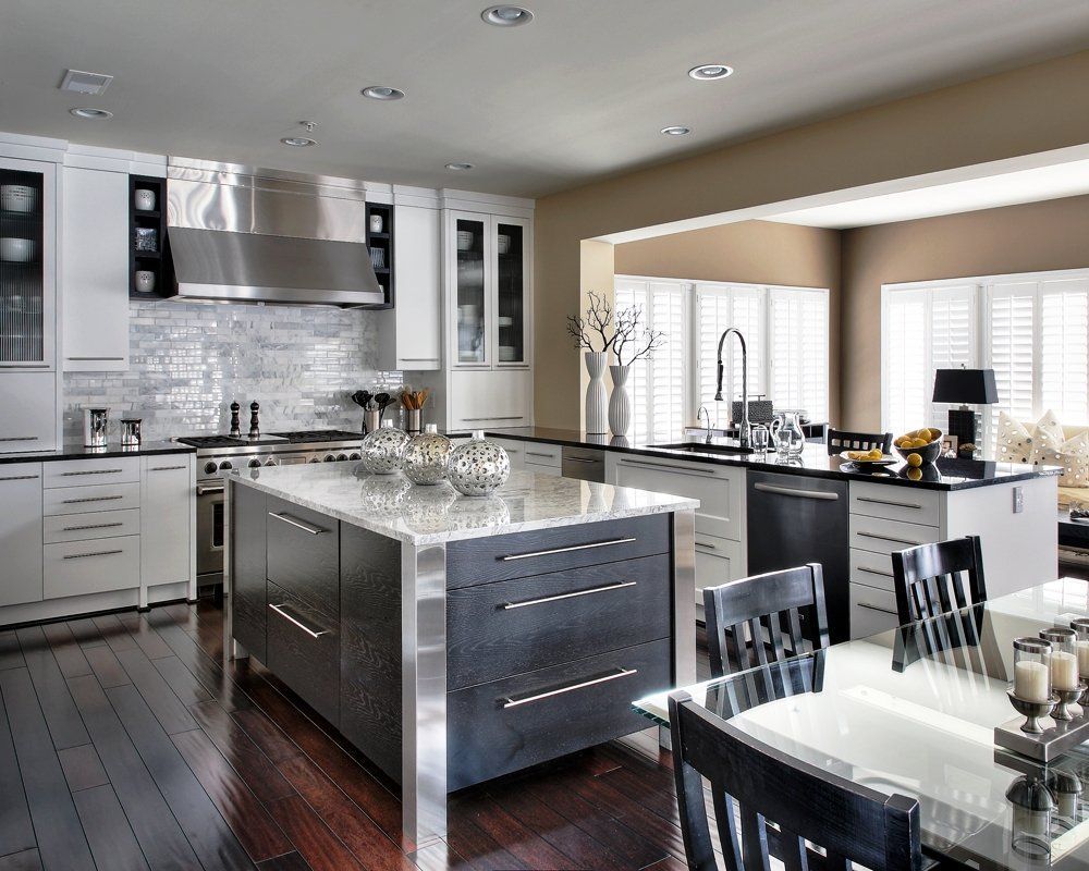 Modern kitchen with white cabinets, stainless steel appliances, and dark wood flooring.