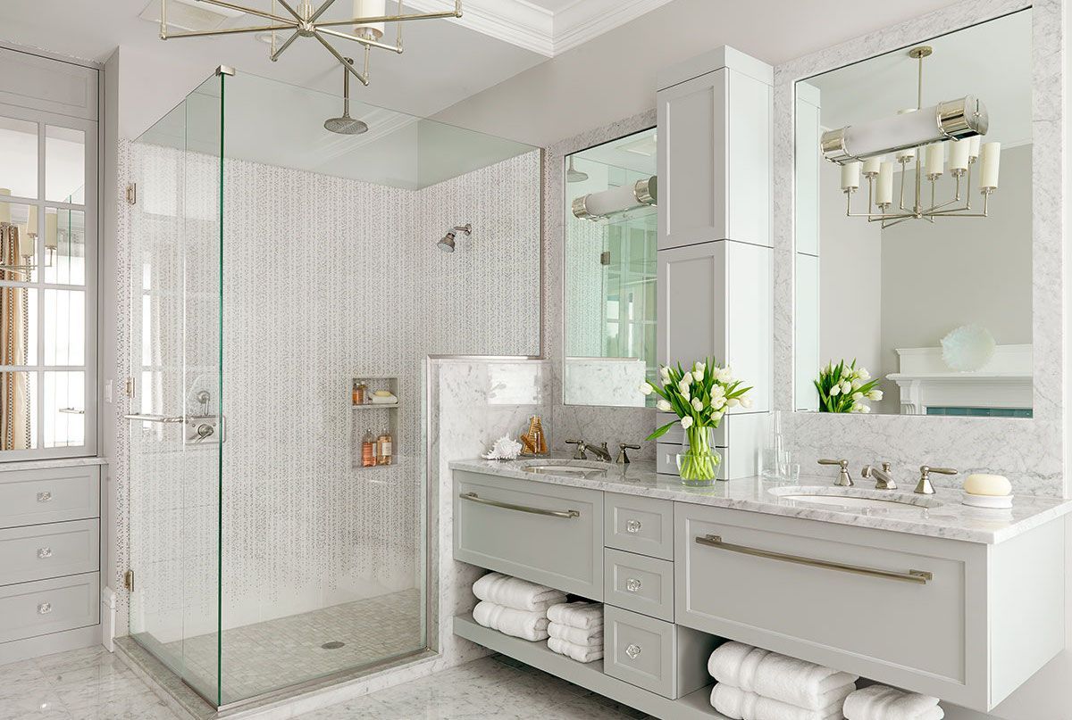 Bright, modern bathroom with tiled shower, double sink vanity, and tall storage cabinet.