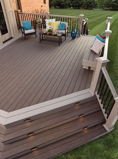 Composite deck with stairs, seating, and a grassy lawn. Beige and gray tones.