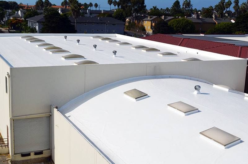 A white roof with a lot of skylights on it