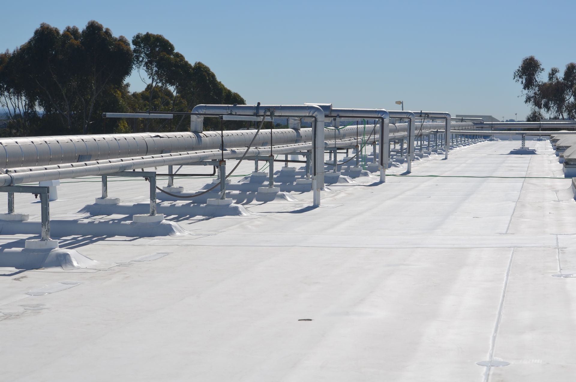 A white roof with a lot of pipes on it