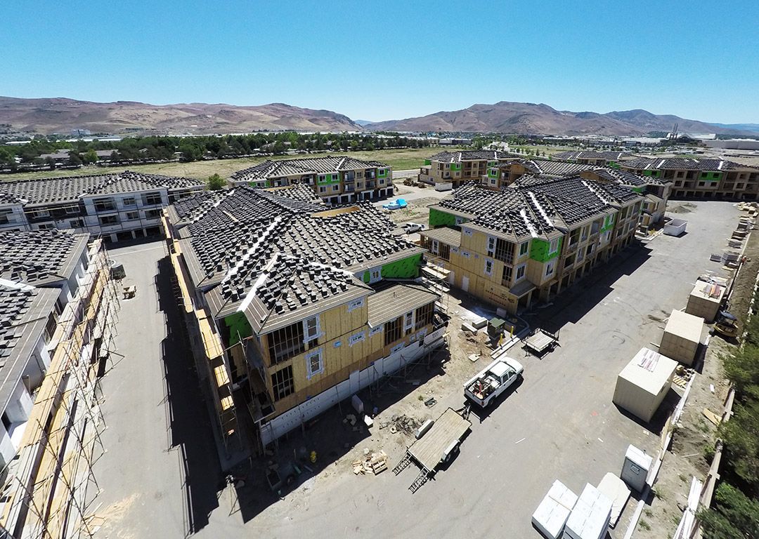 An aerial view of a building under construction with mountains in the background.