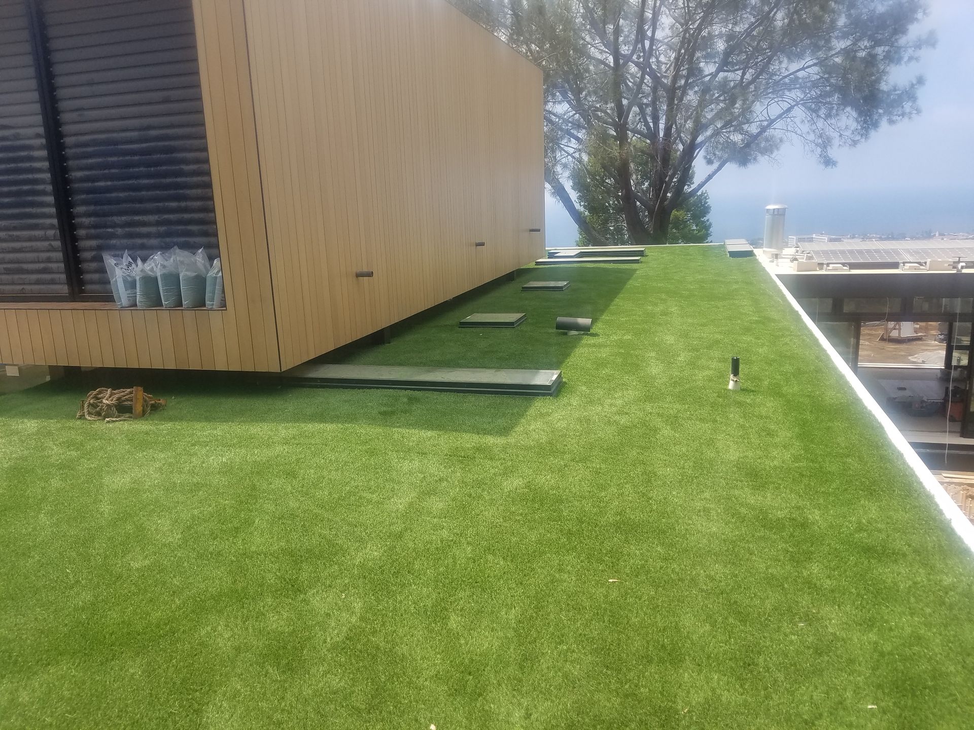 A house with a green roof and a tree in the background.
