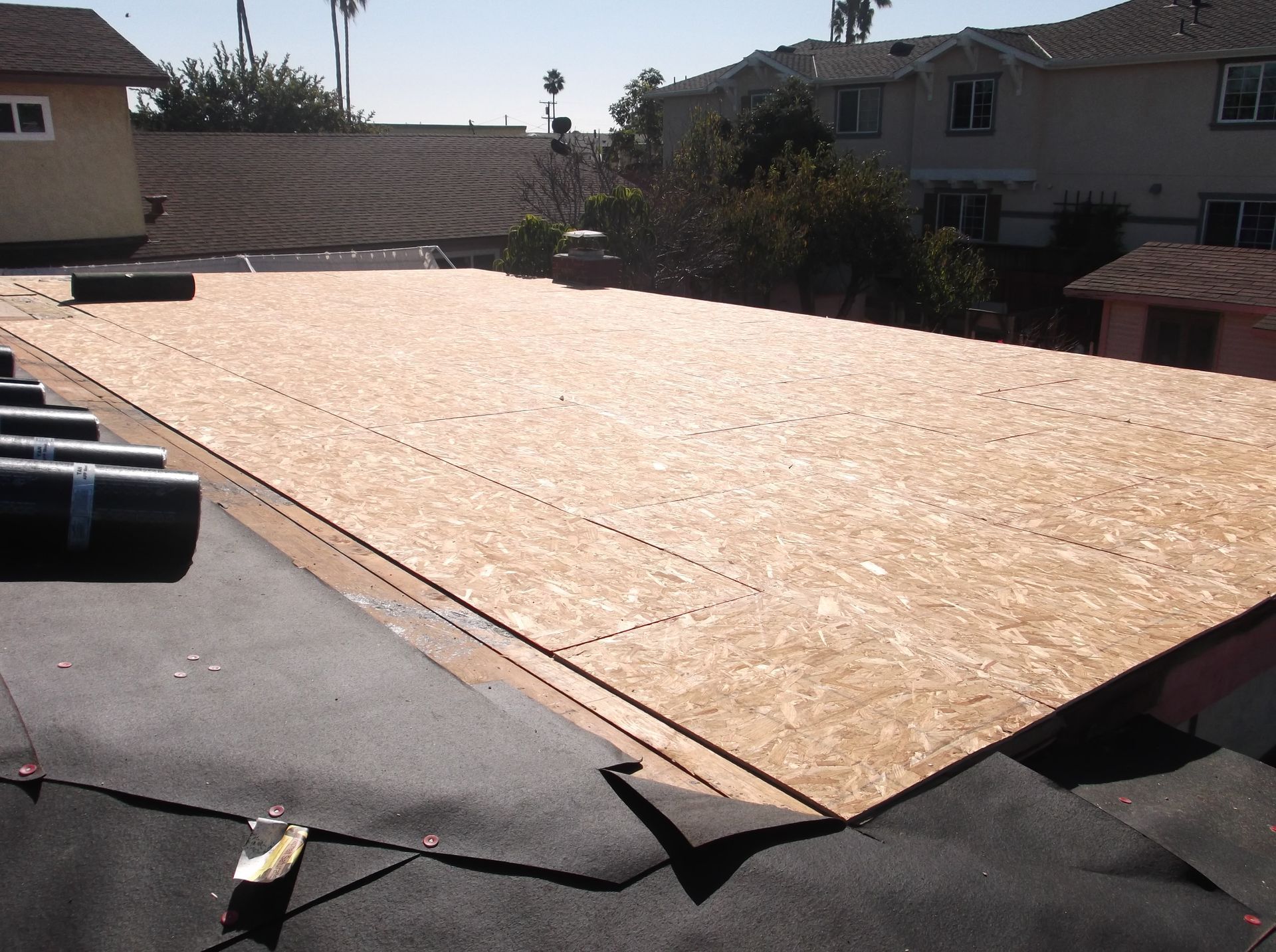 A large piece of plywood is sitting on top of a roof