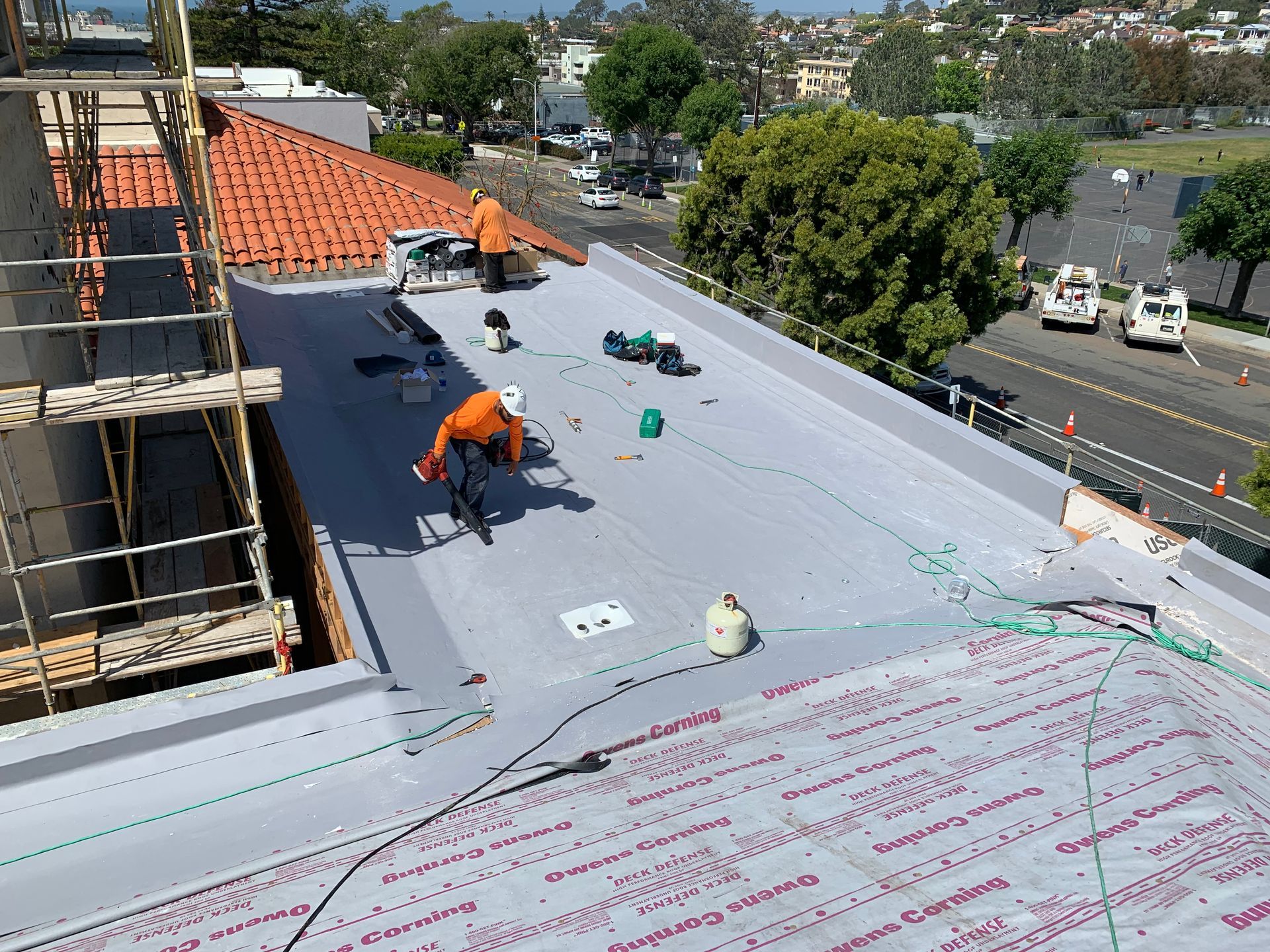 A man is working on the roof of a building.