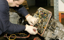 mechanics repairing a car transmission
