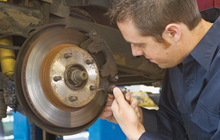 mechanics repairing a car's brakes