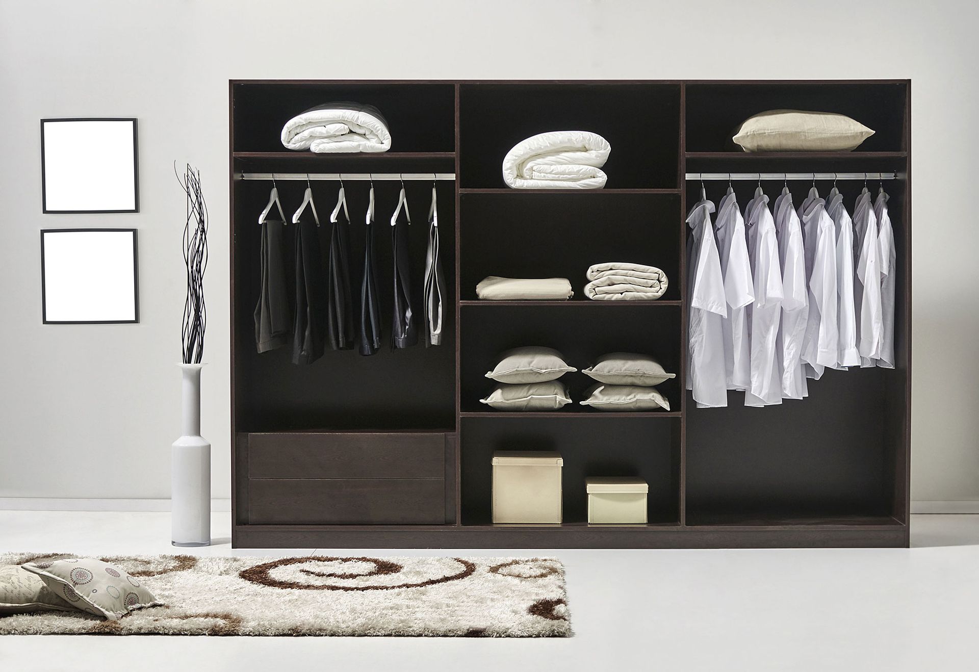 Dark wood closet with hanging clothes, folded linens, and a rug in a minimalist room.