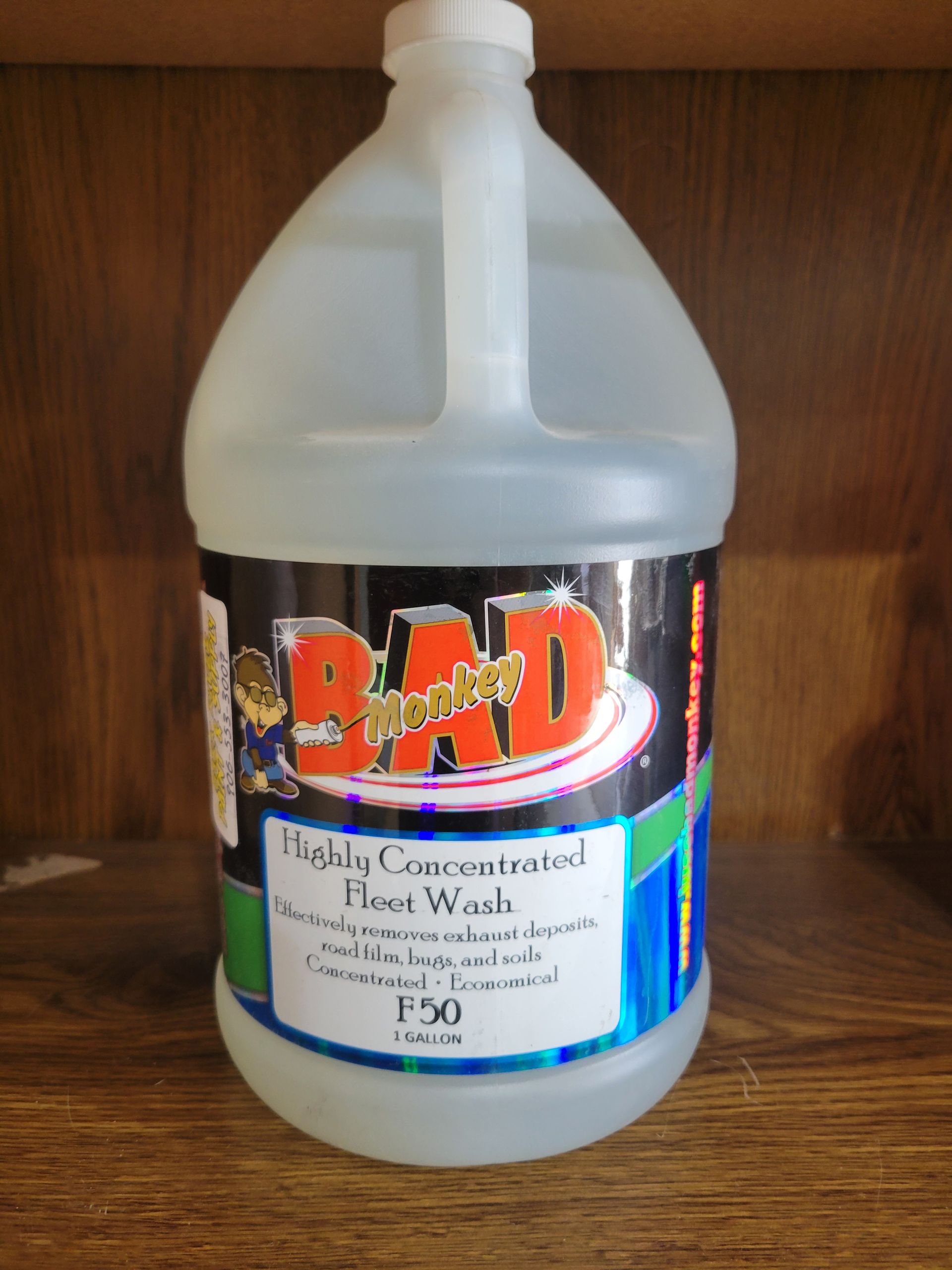 Large plastic jug with black-and-white label and colorful logo on a wooden shelf.
