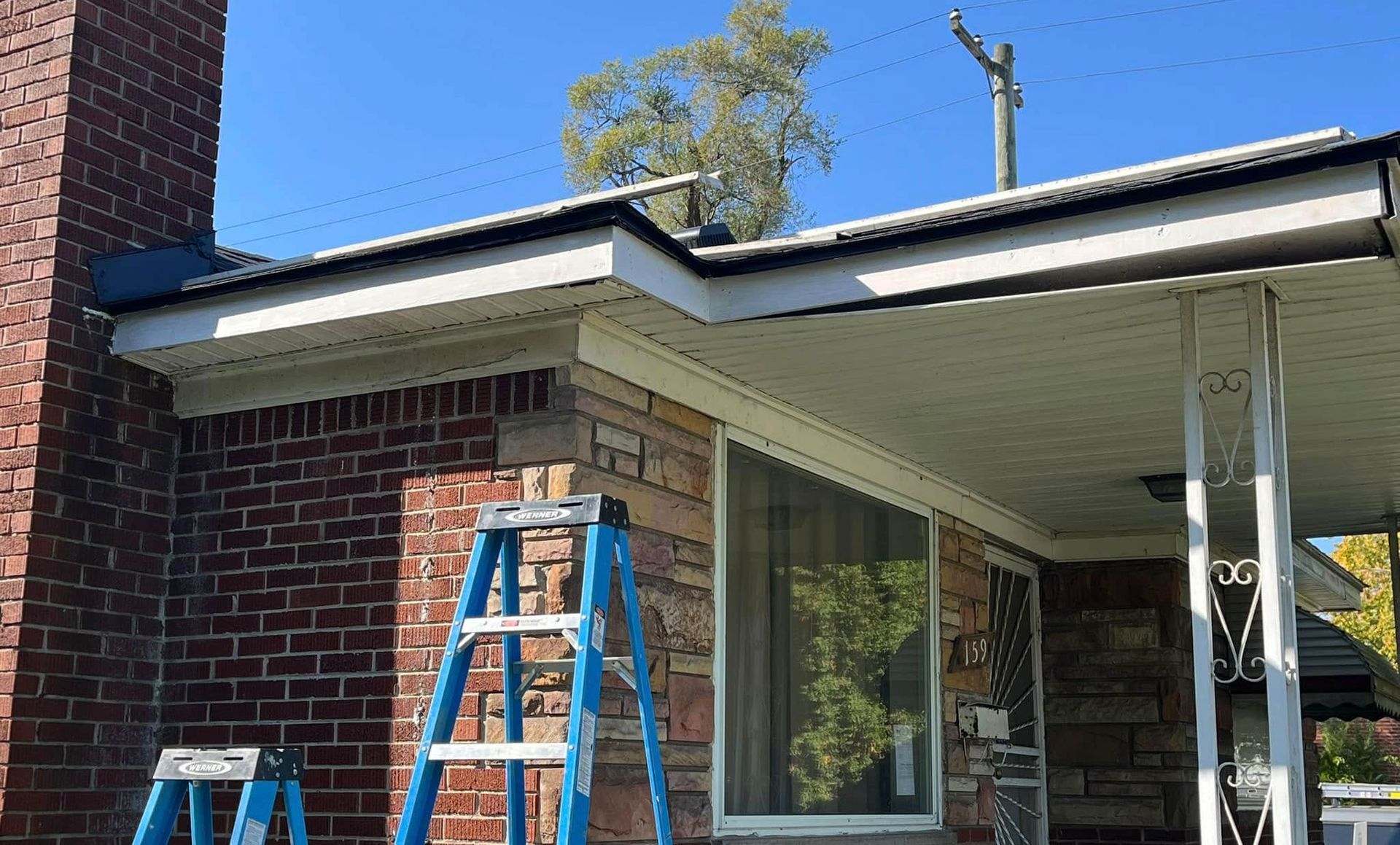 Brick house with a ladder propped up next to the building's exterior.