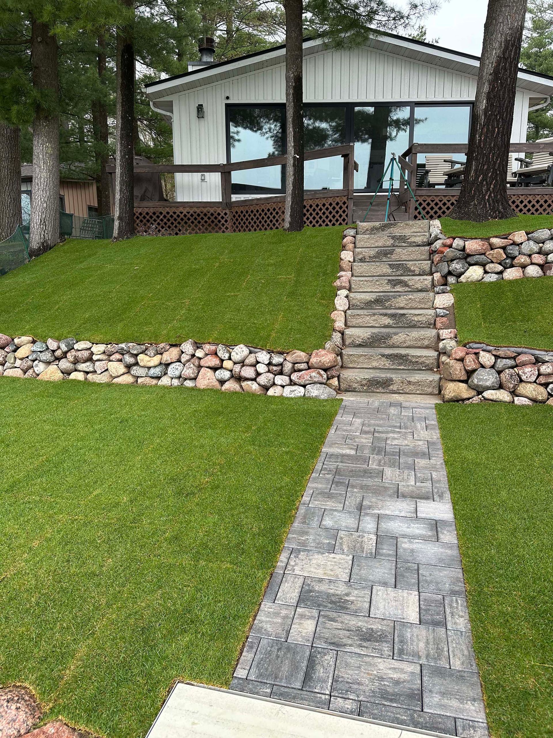 A walkway leading to a house with stairs leading up to it.