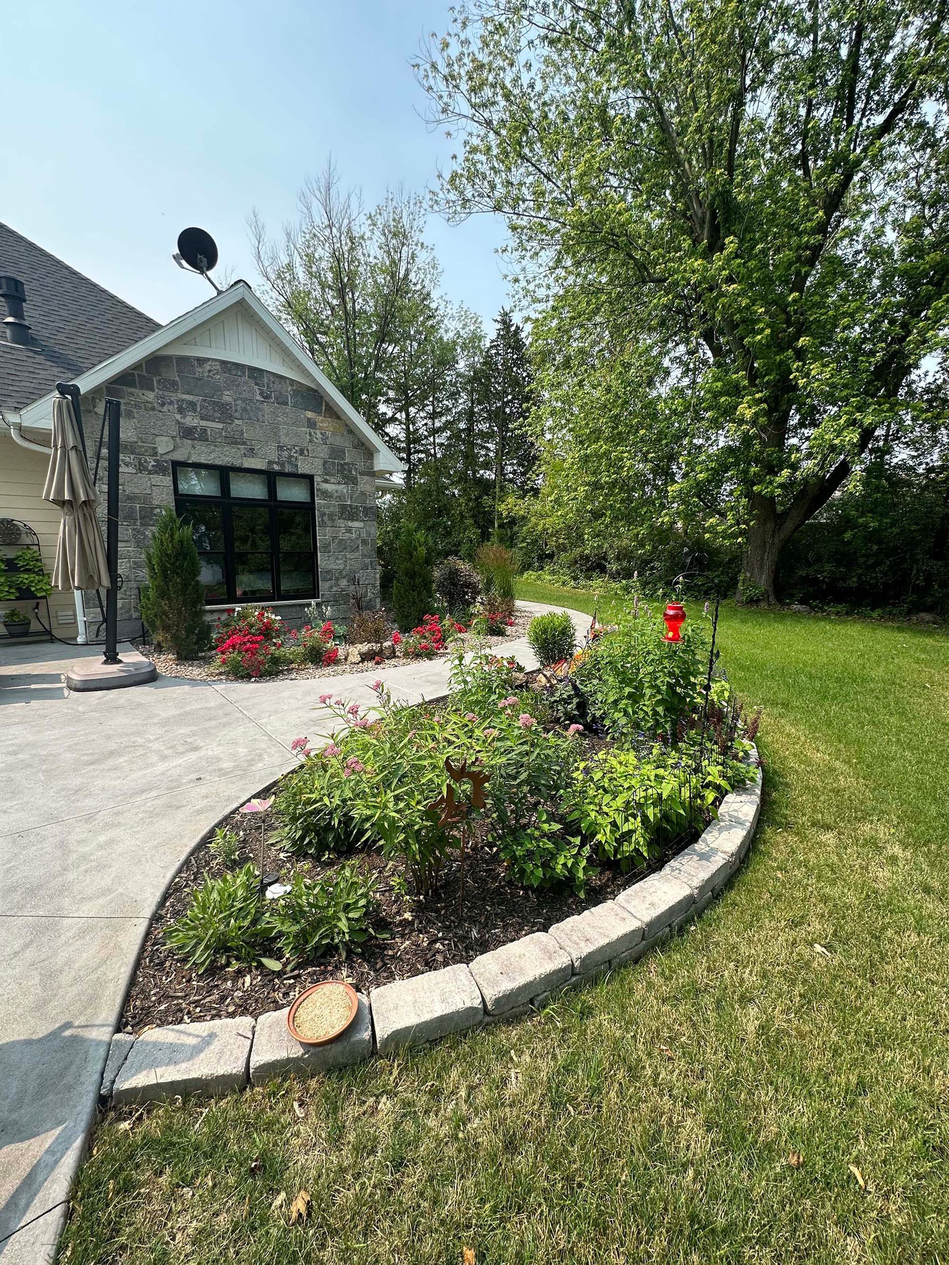 A house with a patio and a garden in front of it.
