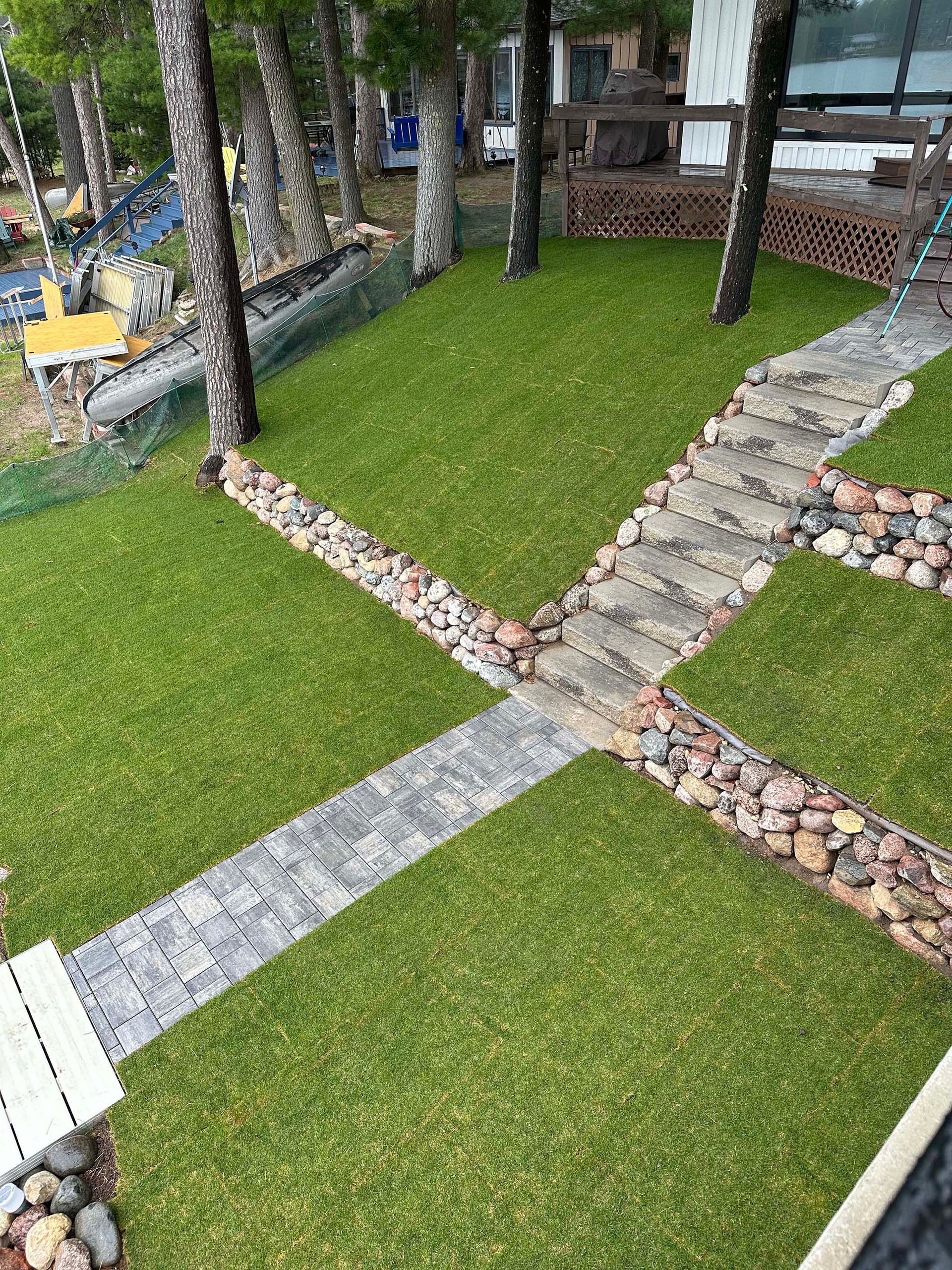 A stone walkway going through a lush green lawn.