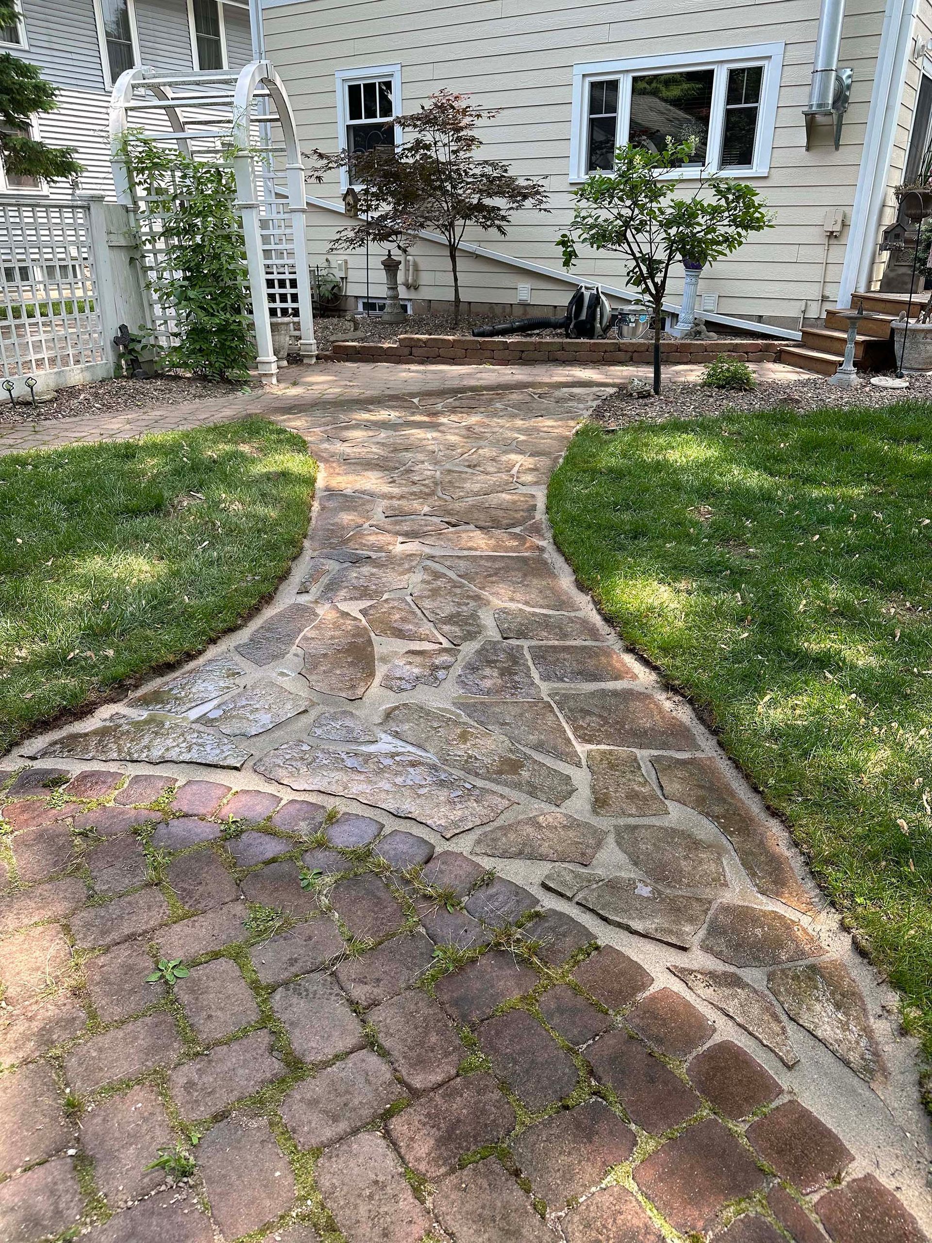 A brick walkway leading to the back of a house.