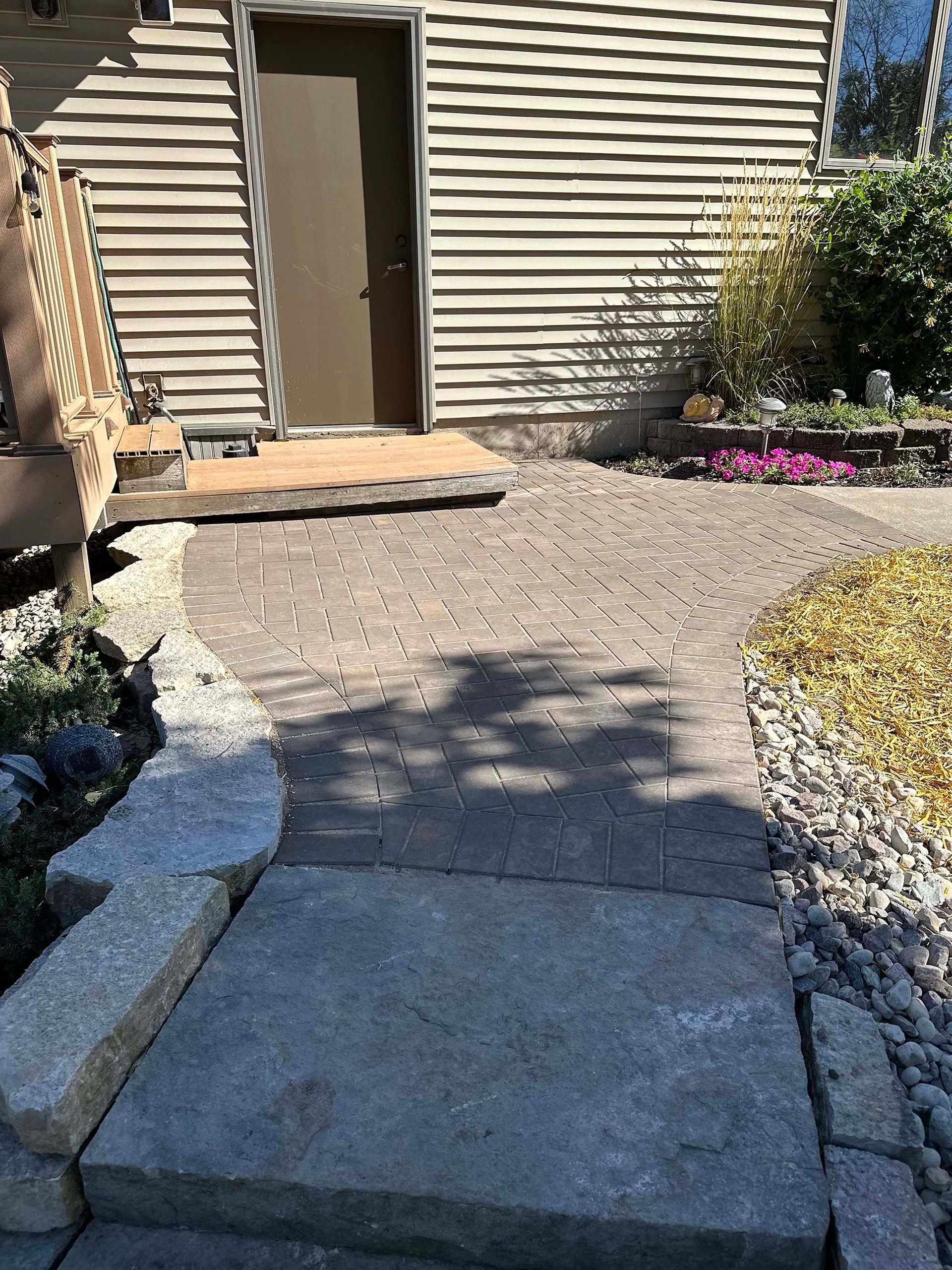 There is a brick walkway leading to the front door of a house.