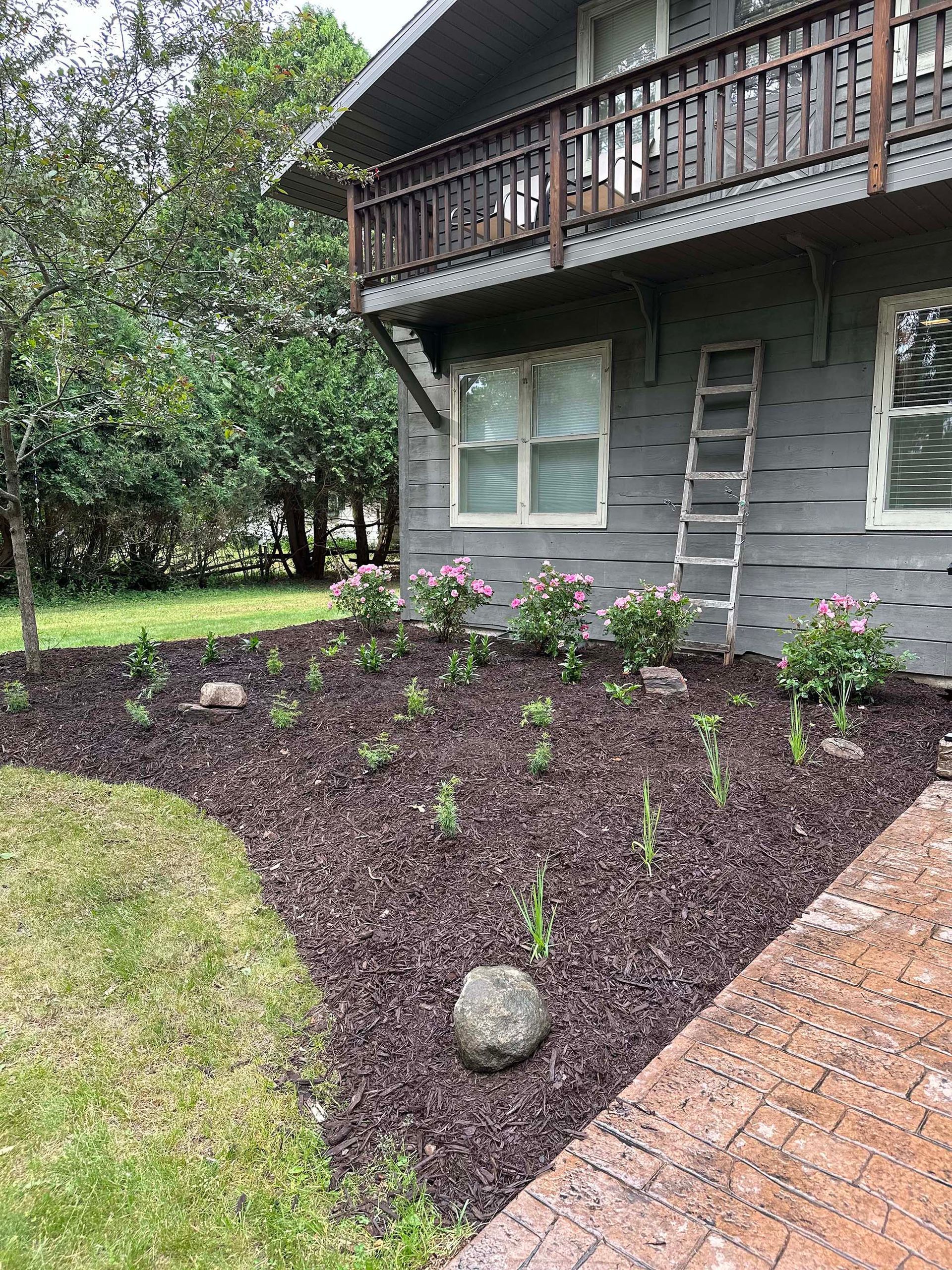 A house with a deck and a ladder in front of it.