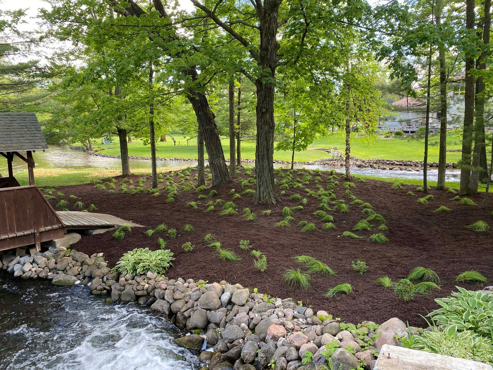 There is a bridge over a stream in the middle of the woods.