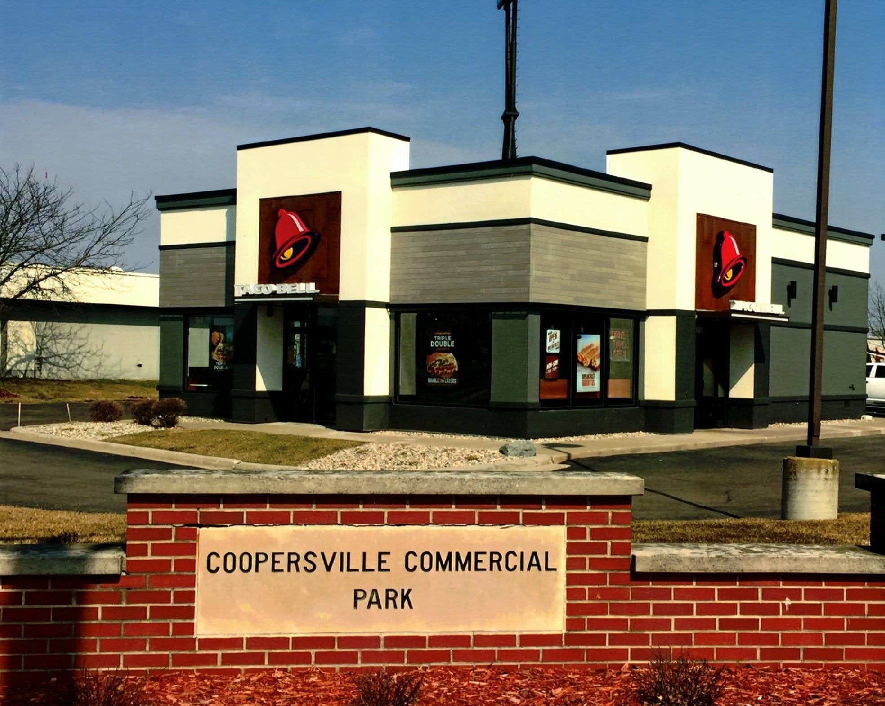 A sign for coopersville commercial park is on a brick wall