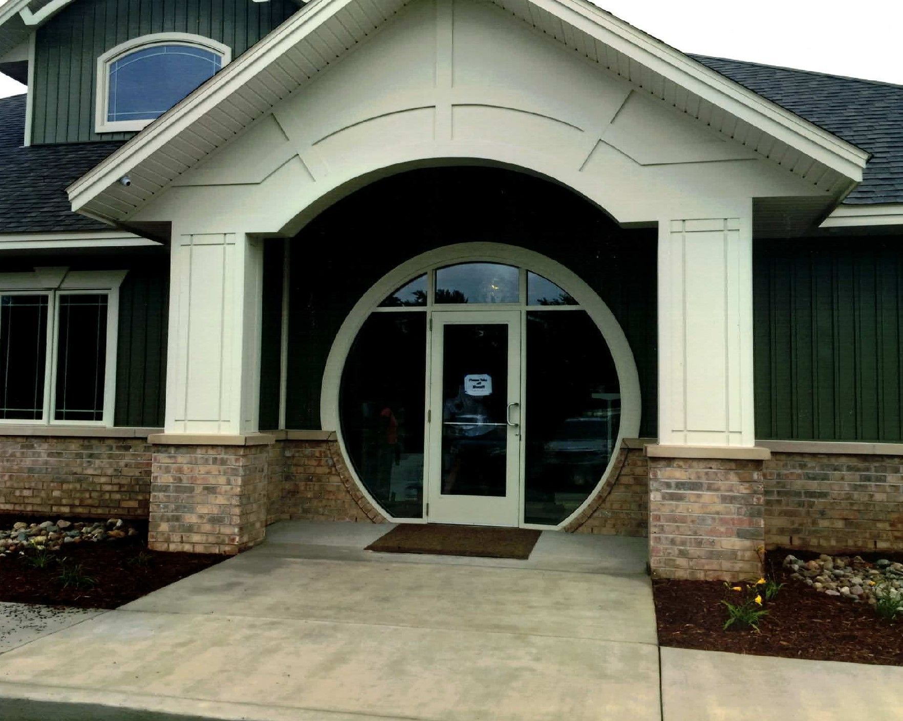 A green and white building with a round door