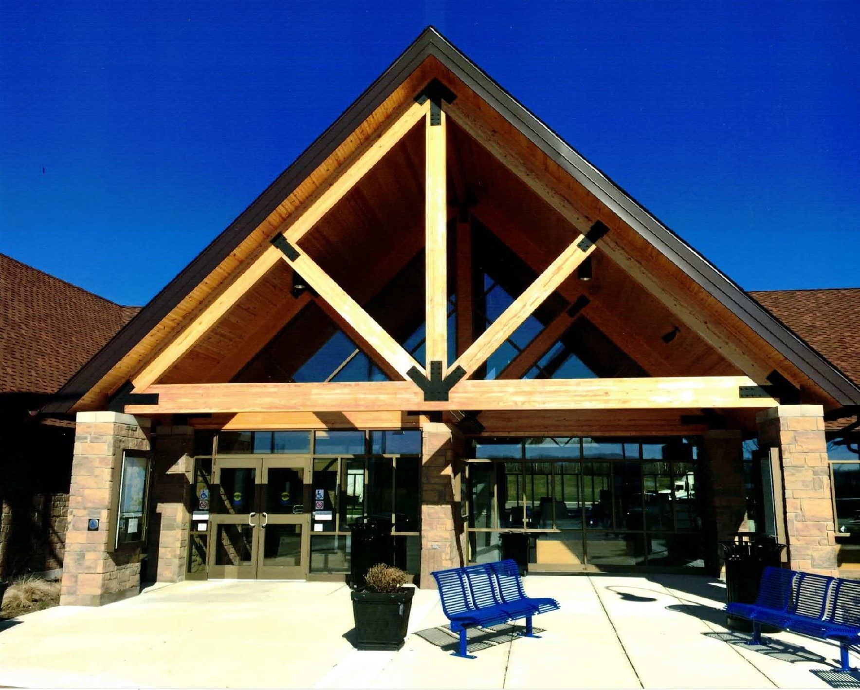 A triangle shaped building with a blue bench in front of it