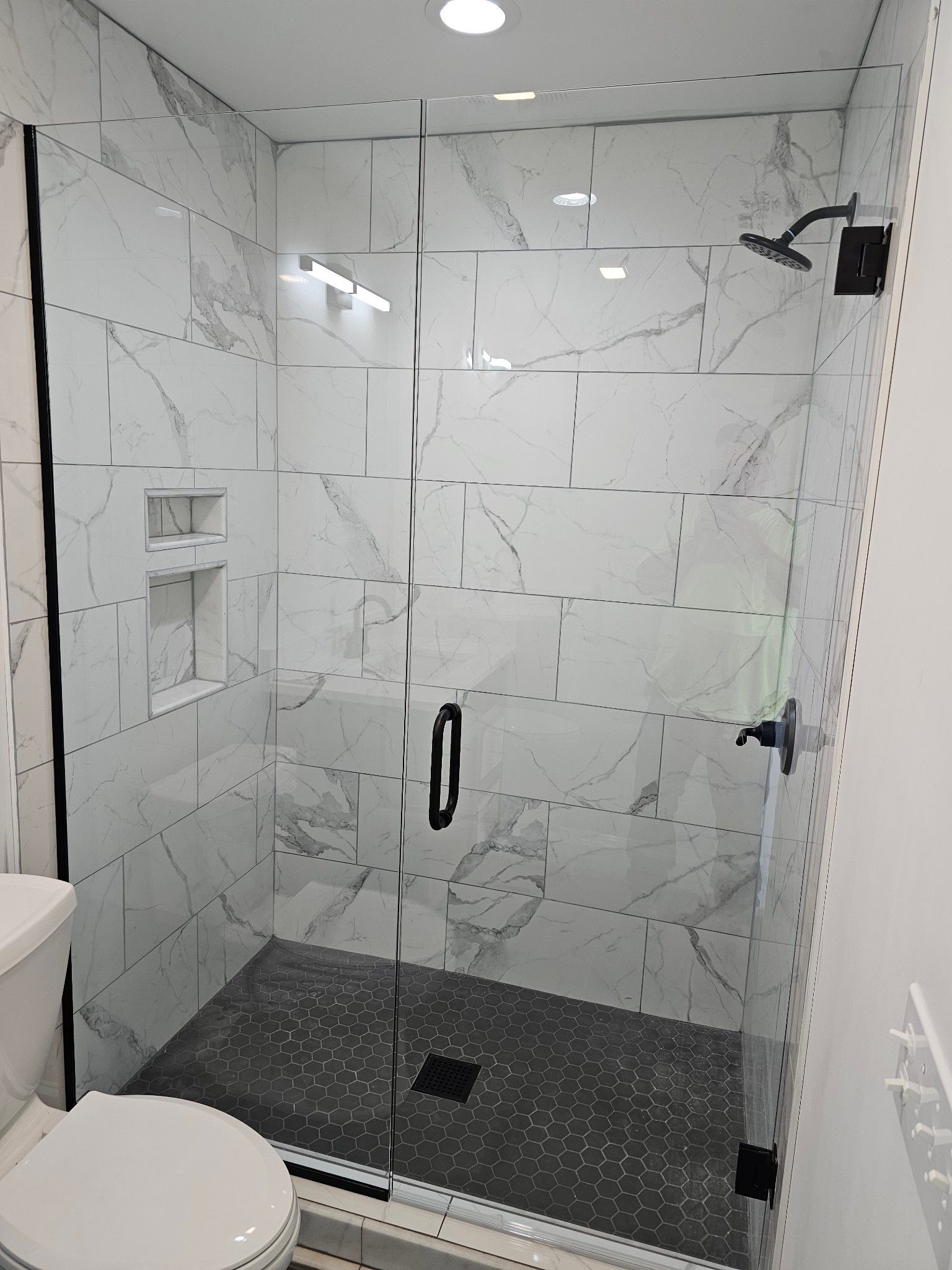 A bathroom with a walk in shower and a toilet.