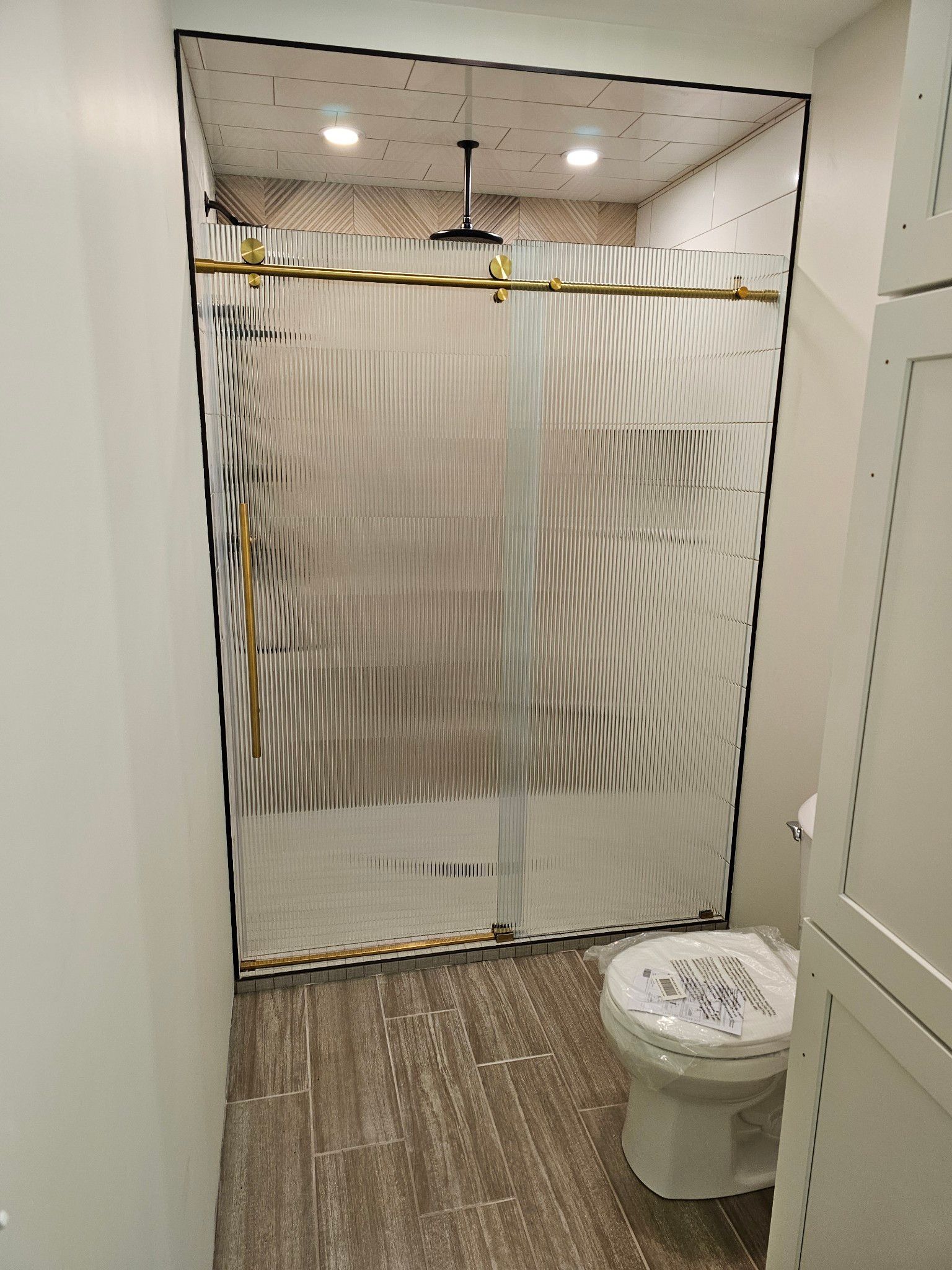 A bathroom with a toilet and a shower stall being built.