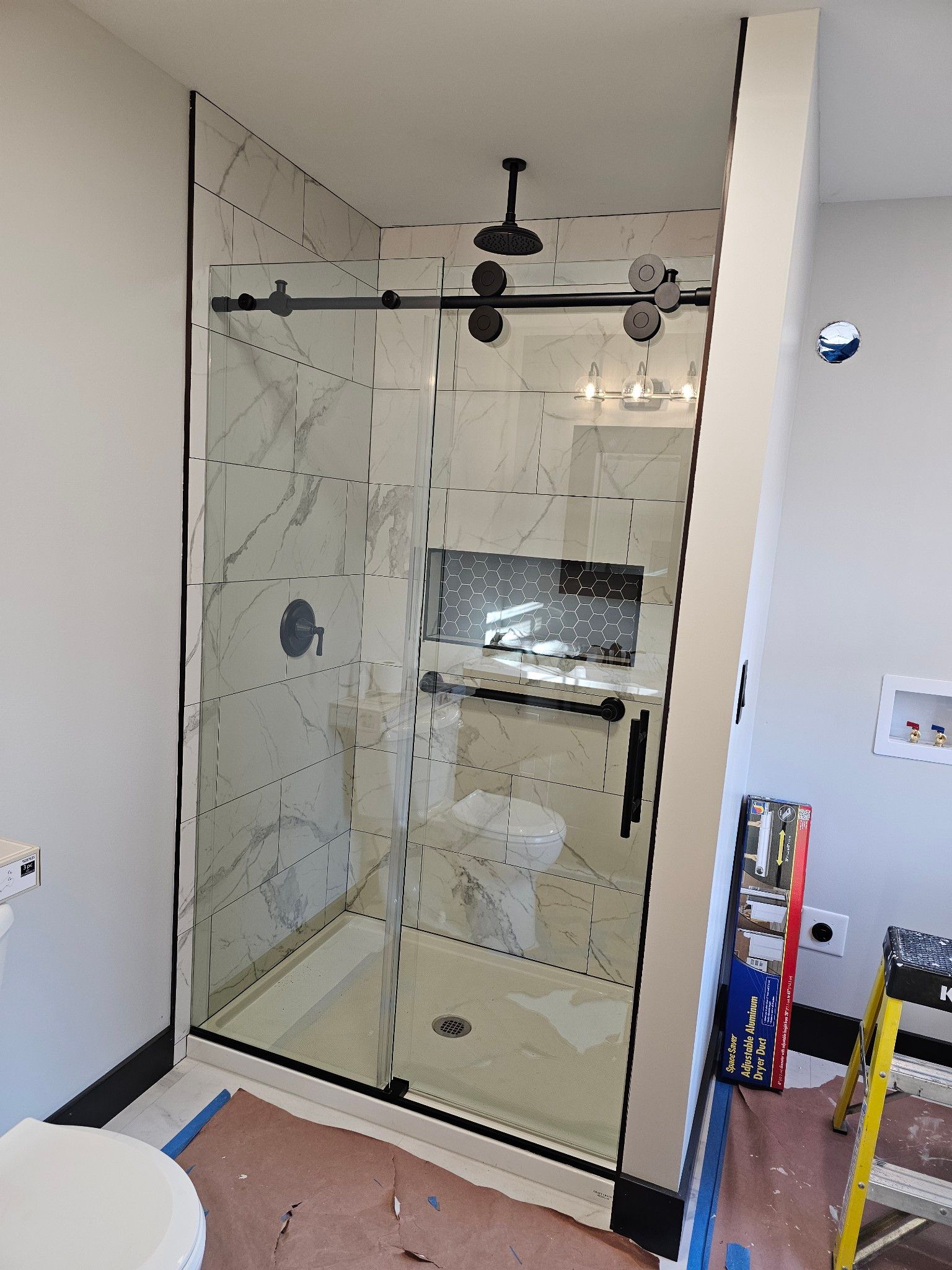 A bathroom with a sliding glass shower door and a toilet.