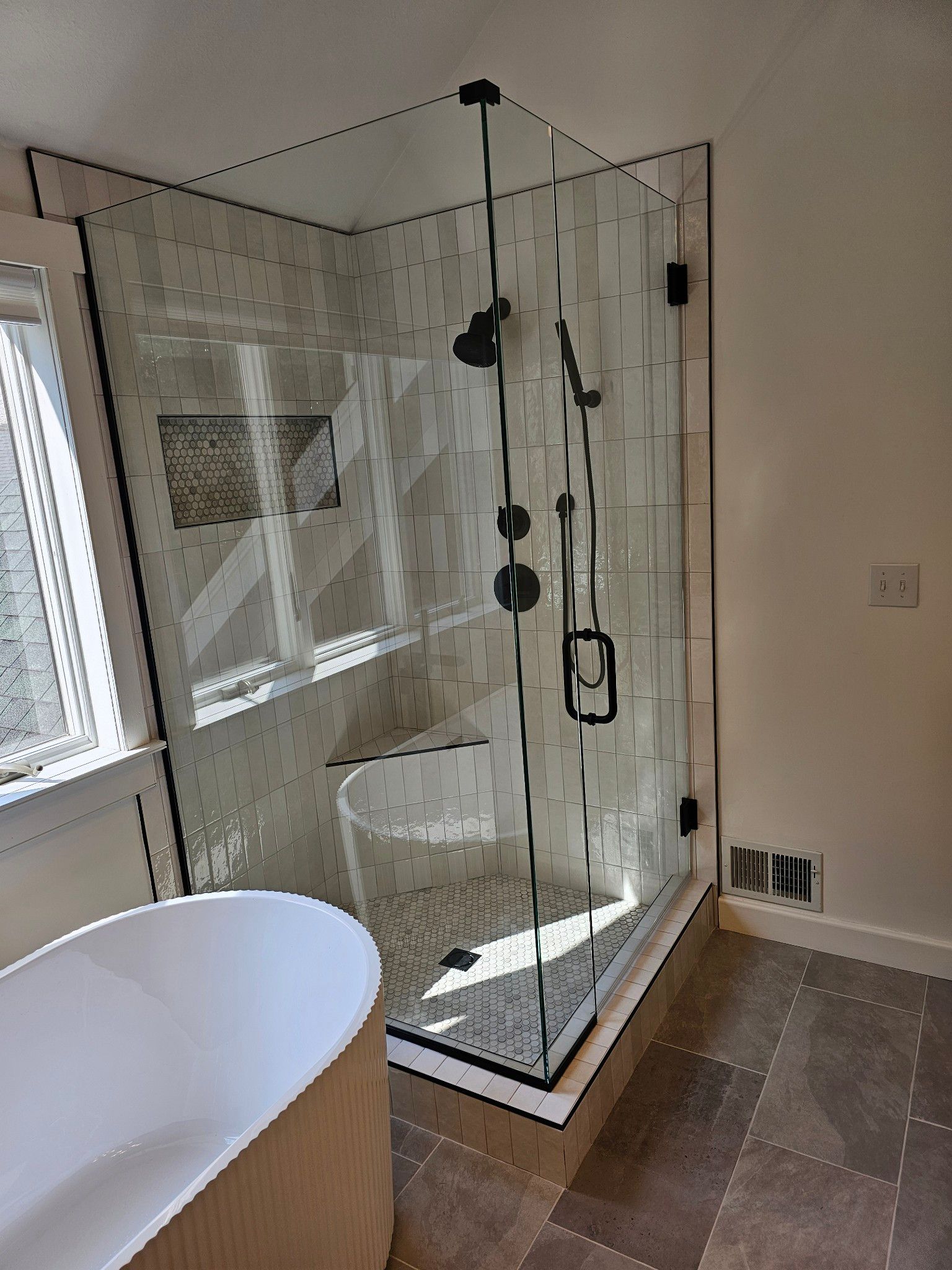 A bathroom with a walk in shower and a bathtub.