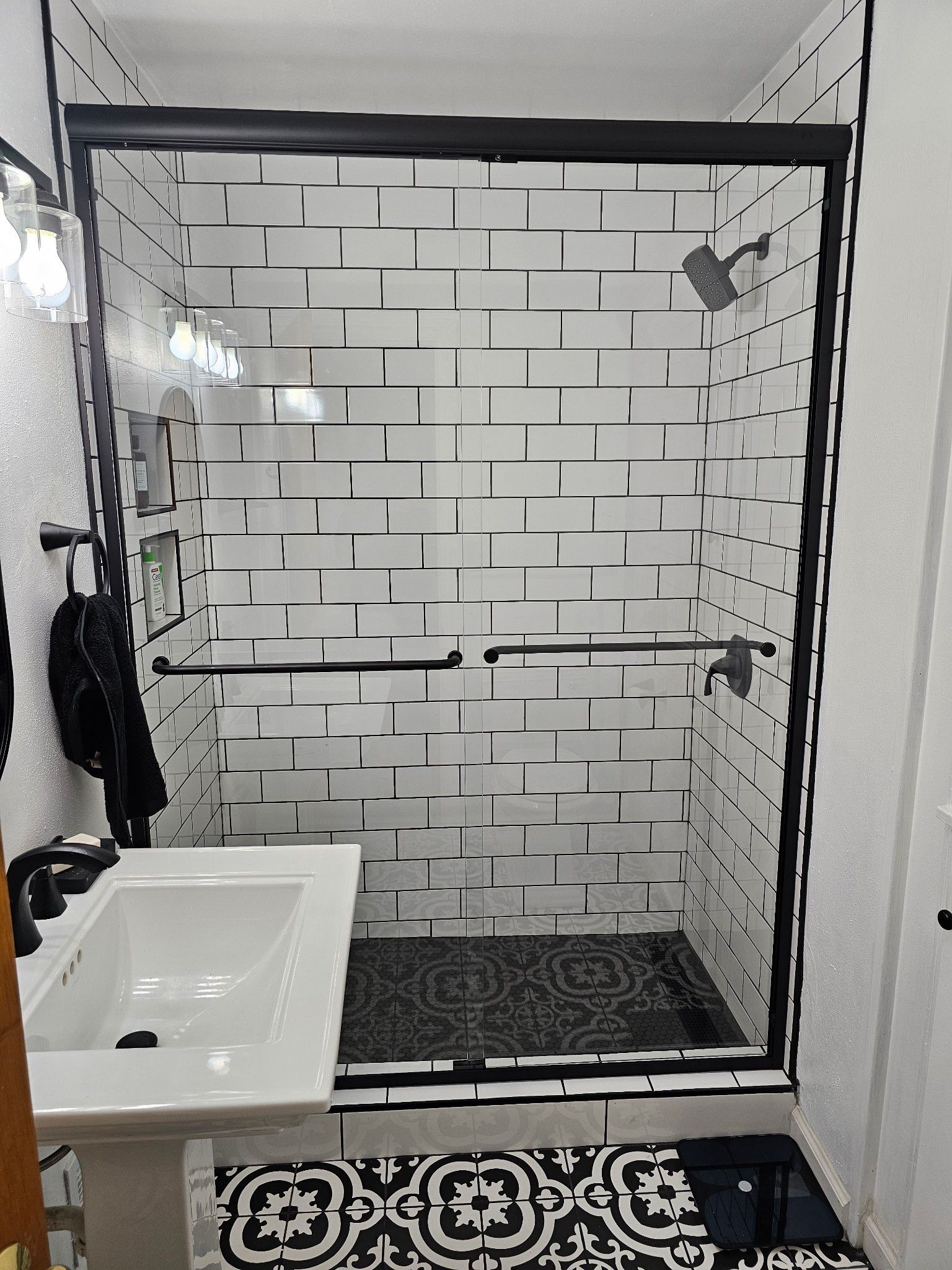 A bathroom with a sliding glass shower door and a sink.