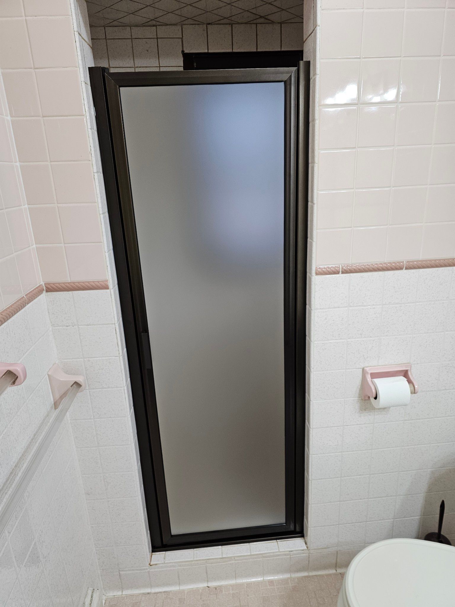 A bathroom with a toilet and a shower door.