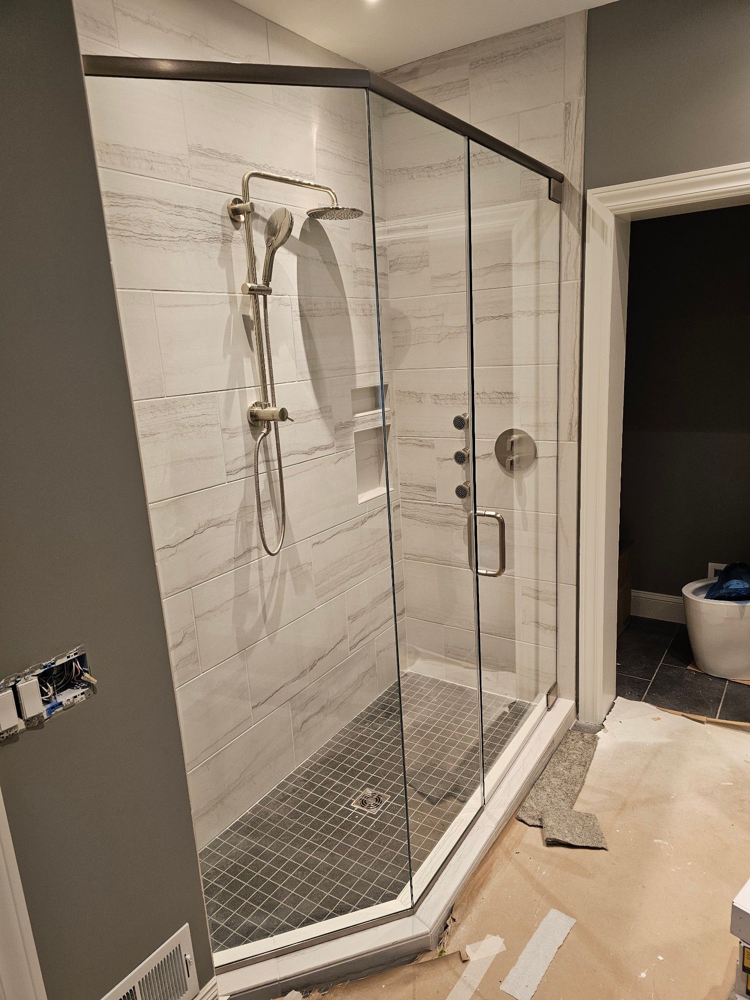 A bathroom with a walk in shower and a tub.