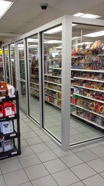 A grocery store with a lot of shelves and glass doors.
